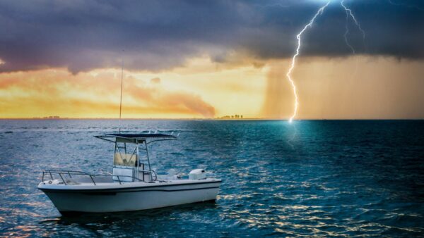 a boat sailing in a lightning storm