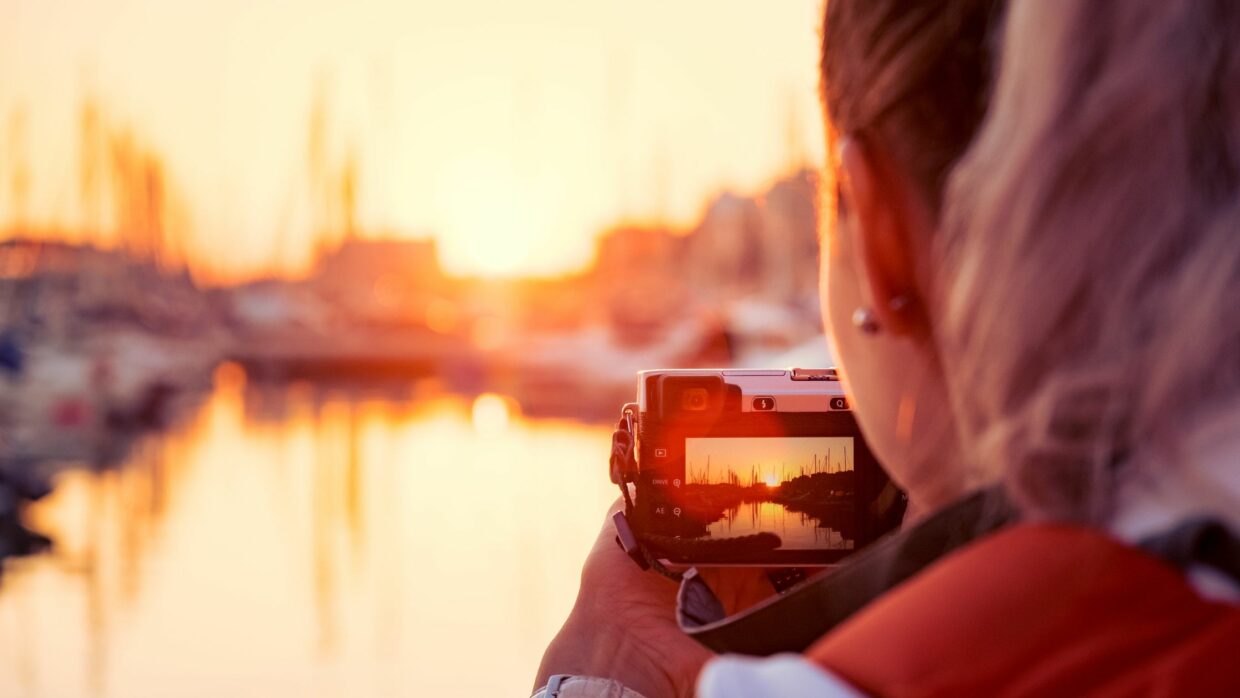 woman taking a picture of boats docked at a marine with a professional camera